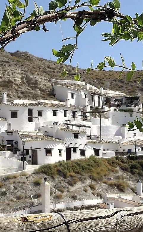 Whitewashed cave houses built into the hillside in Galera, Granada