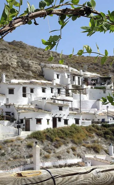 Whitewashed cave houses built into the hillside in Galera, Granada