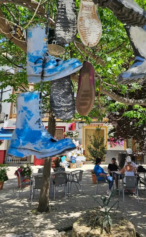 Painted boots hanging from a tree in Castril town square, Granada