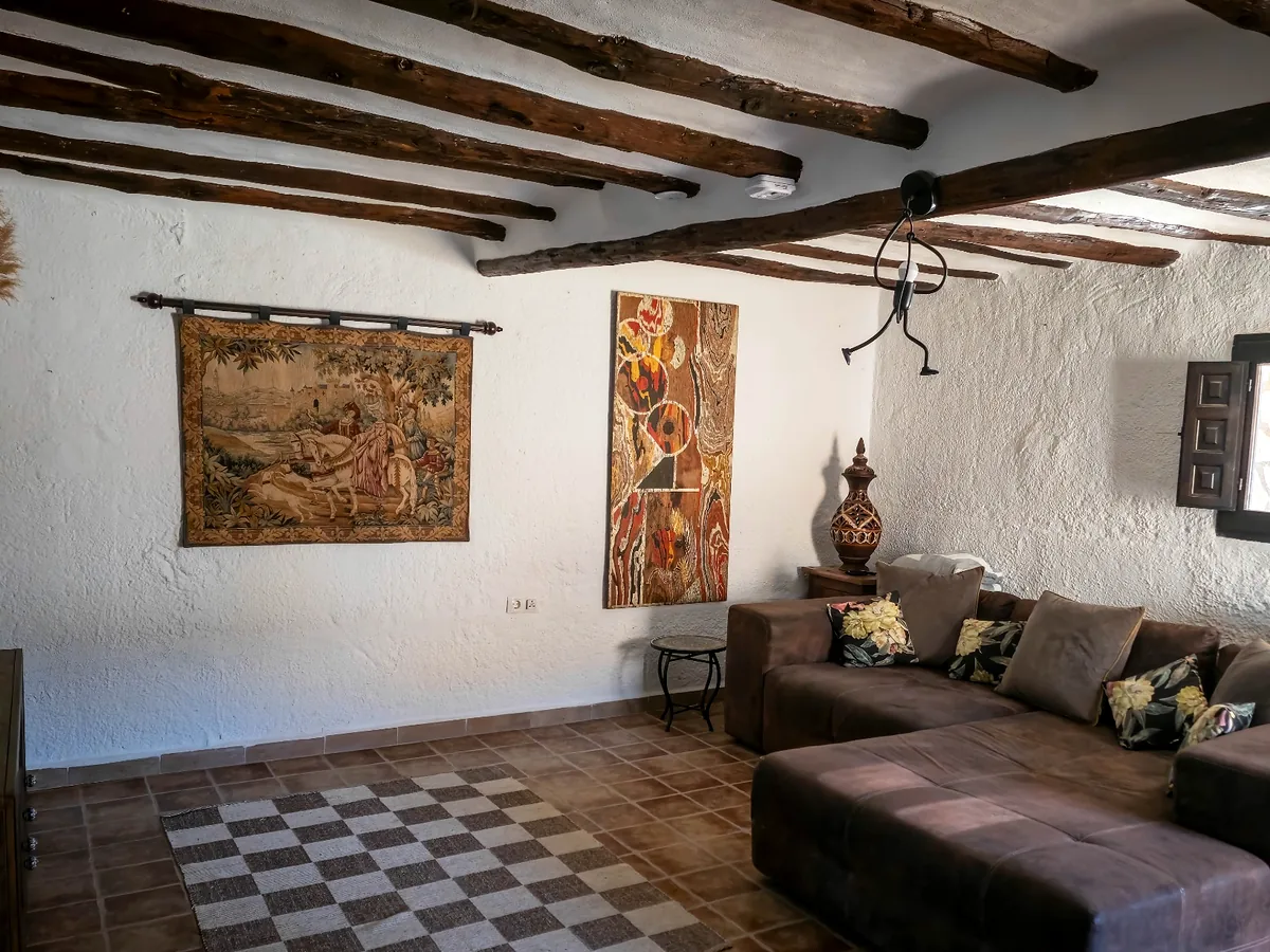 Spacious cave-house lounge with exposed beams at Leonard's Lookout